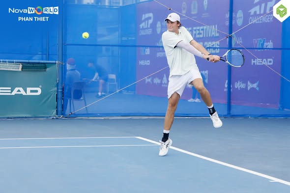 Một tay vợt trẻ thực hiện cú đánh trái hai tay trên sân thi đấu ATP Challenger tại NovaWorld Phan Thiết